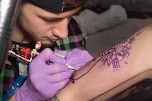 tatuador está haciendo tatoo foto