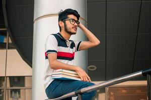 young attractive guy sits on a street with books photo