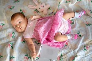 Adorable newborn girl in pink dress photo