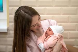 linda mamá con una pequeña hija recién nacida foto