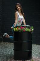 Young beautiful girl smiles on camera and posing across a black brick wall photo