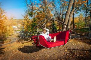 Girl rides on a swing over a cliff photo