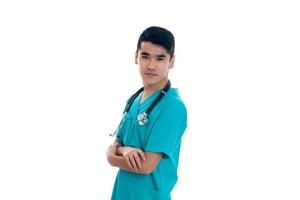 young handsome man doctor posing in uniform isolated on white background in studio photo