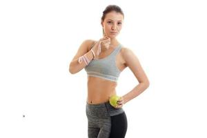 beautiful young girl in grey top looks at the camera and holding a measuring tape and Apple photo