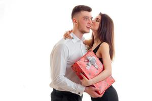 young cute girl kissing a guy in that he brought her a gift isolated on a white background photo