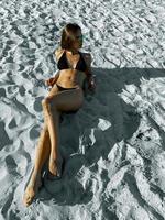 Glamour young lady sunbathing on white sand photo