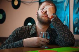 foto horizontal de un borracho con una copa de brandy en el bar