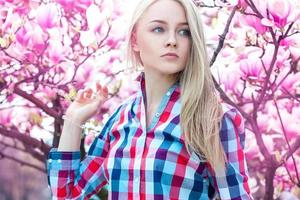 Luxury portrait of serious young blonde girl with flowers photo