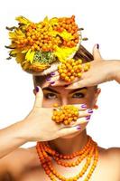 modelo de moda ocultar la cara detrás de la mano con accesorios de serbal y flores foto