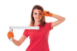 portrait of young cheerful brunette builder girl makes renovation isolated on white background photo