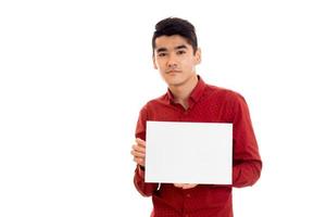 serious young guy in red t-shirt with empty placard looking at the camera isolated on white background photo