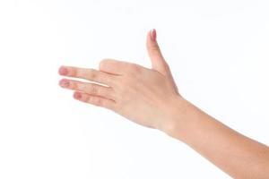 mano femenina extendida hacia un lado y mostrando el gesto con un dedo índice doblado con las palmas rectas aislado en fondo blanco foto