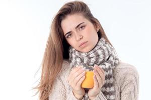 young girl dressed warmly and holding  cup of tea in the hands isolated on white background photo