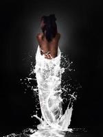 Brunette girl with milk splashes photo