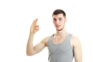 handsome young guy with a beard looks into the camera and shows the hand gesture photo