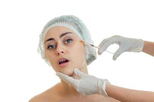 a young girl in a medical hat with the open mouth which the doctor on her face makes tuck in white gloves close-up photo