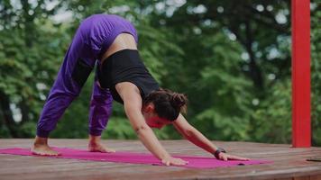 Frau führt Yoga-Posen durch und dehnt sich auf der Freilichtbühne aus video