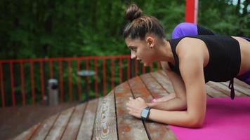 Woman performs yoga poses and stretches on outdoor stage video