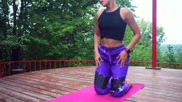 kvinna utför yoga poser och sträckor på utomhus- skede video