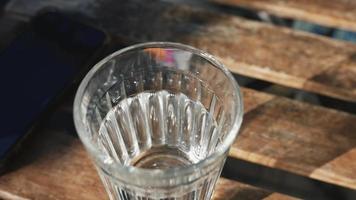 Glas Wasser auf Tisch im Freien video