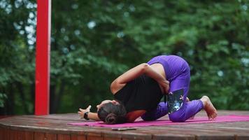 kvinna utför yoga poser och sträckor på utomhus- skede video