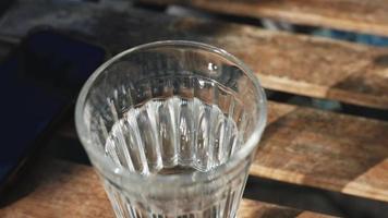 Glas Wasser auf Tisch im Freien video
