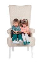 Children sit in a chair with books photo