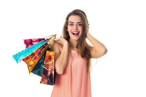 una chica feliz mantiene la pelota detrás de la cabeza y, por otro lado, muchos paquetes están aislados en un fondo blanco foto