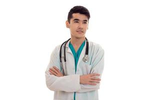 handsome male doctor in uniform with stethoscope posing isolated on white background photo