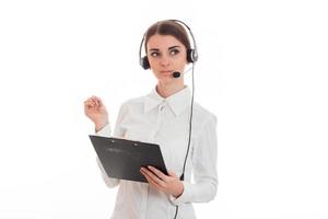 portrait of young attractive call center worker girl with headphones and microphone posing isolated on white background photo