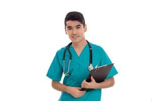 a young doctor in the blue dress with stethoscope smiles and holds the Tablet photo