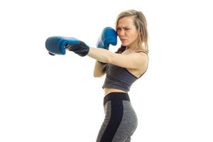 Slim girl stands sideways in boxing gloves is isolated on a white background photo