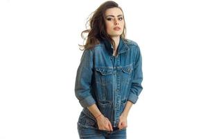 young beautiful girl in jeans suit stands up straight and looks in forward photo