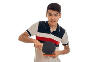 young guy holding tennis rackets and looking directly photo