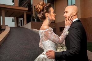 sensual portrait of young beautiful married couple in fashionable wedding suits photo