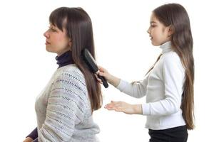 girl combing hair to her mum photo