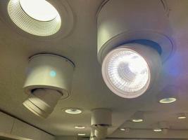 Bright luminous spotlights on the ceiling to illuminate the room photo