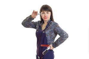 estilista de mujer adulta con herramientas en las manos lleva un delantal foto
