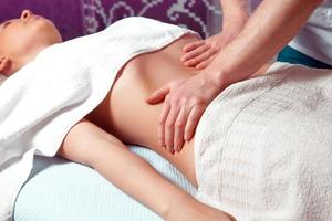 close up photo of masseur therapist makes belly massage for girl