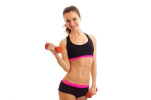 athletic young girl at the top holding a dumbbell and smiling photo