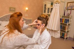 woman makes makeup young beautiful bride photo
