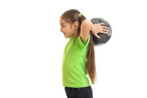 young little girl plays with soccer ball photo