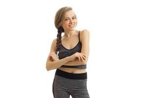 cheerful beautiful fitness blonde stands in front of the camera in sportswear and smiling photo