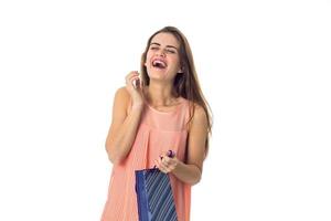 Una chica alegre con un vestido que sostiene un paquete azul aislado de fondo blanco foto