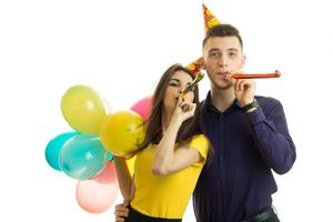 beautiful and funny girl with boyfriend celebrate birthday hold balls and blow horns photo