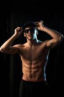 Elegance muscular male on black background photo