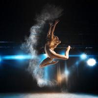 bailarina adulta rubia en salto en el escenario del teatro foto