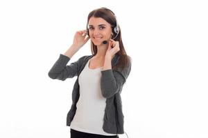 beautiful young girl in headphones and gray jacket turned aside and keeps hands the microphone near the face photo