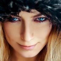 Square portrait of cutie young woman with blond hair and blue eyes in fur hat photo