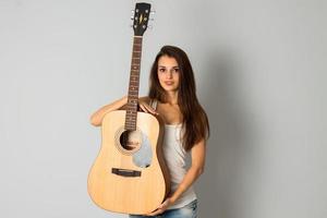 attractive young girl with guitar in hands photo